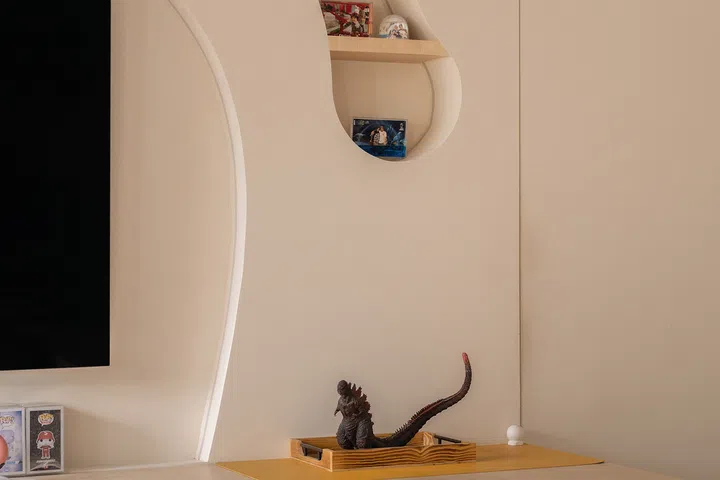 Godzilla and family photographs share the living room with Jumadi’s sneakers.