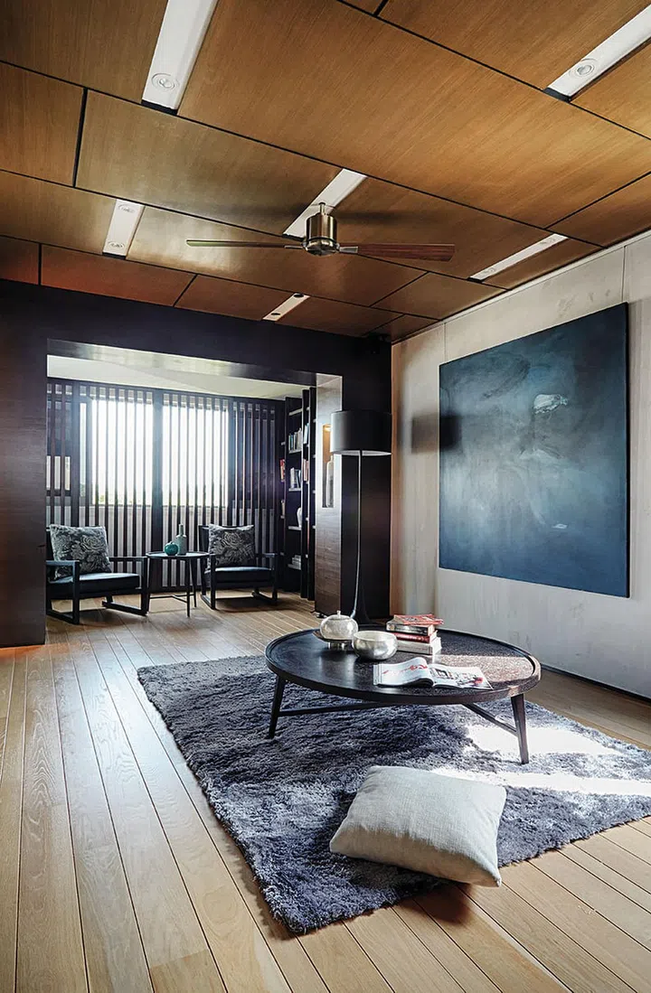 Sliding slatted screens by the window draw the eye away from the lacklustre view and frame the cosy library nook in the living room.