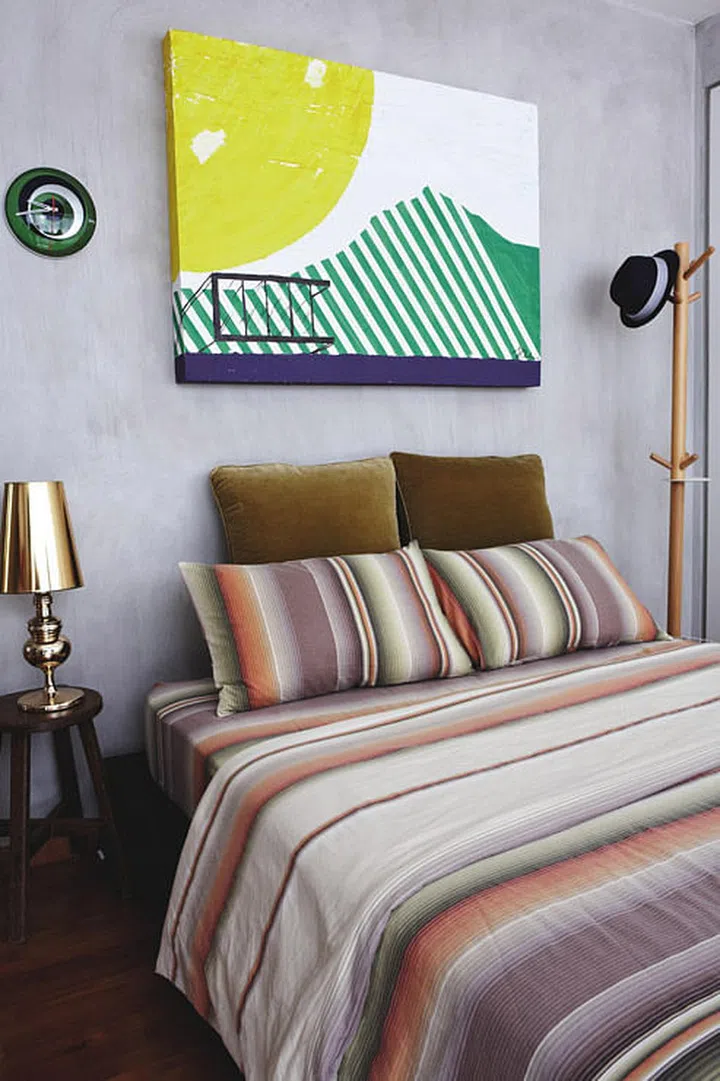 'Field of Lavender' artwork hangs over the bed. The wooden stool is one of a pair spotted outside a flat, and purchased for $50, seen in in interior designer Ong Jia Qi, founder of JQ Ong The Association's 3-bedroom Executive Condominium (EC) in Pasir Ris.