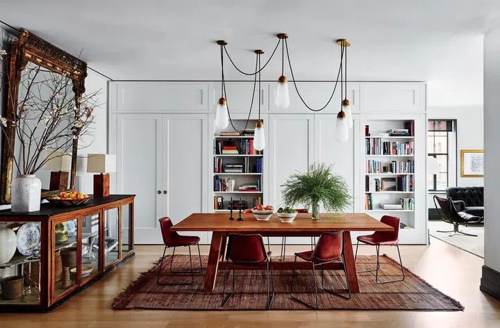 Lights by Apparatus Studio hang above a Ralph Lauren Home table and Sol y Luna chairs in the dining room in Naomi Watts and Liev Schreiber's Manhattan apartment. Image by Douglas Friedman