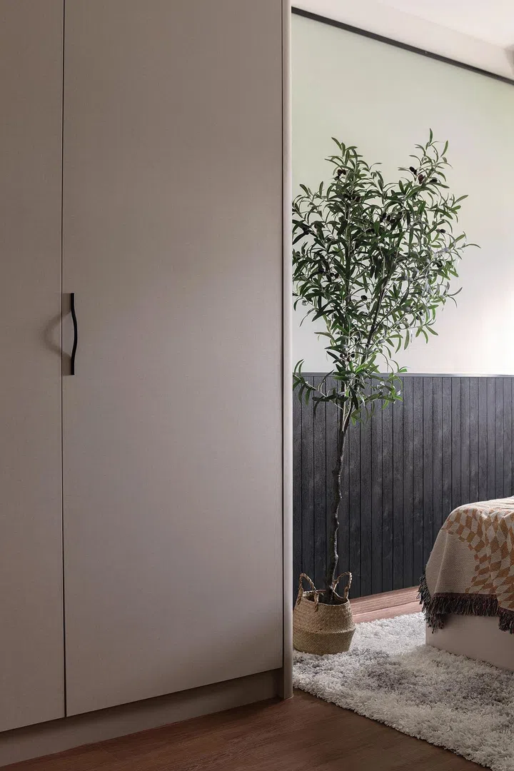 The L-shaped wardrobe is finished with matte laminates for an understated feel that stays consistent with the other design details.