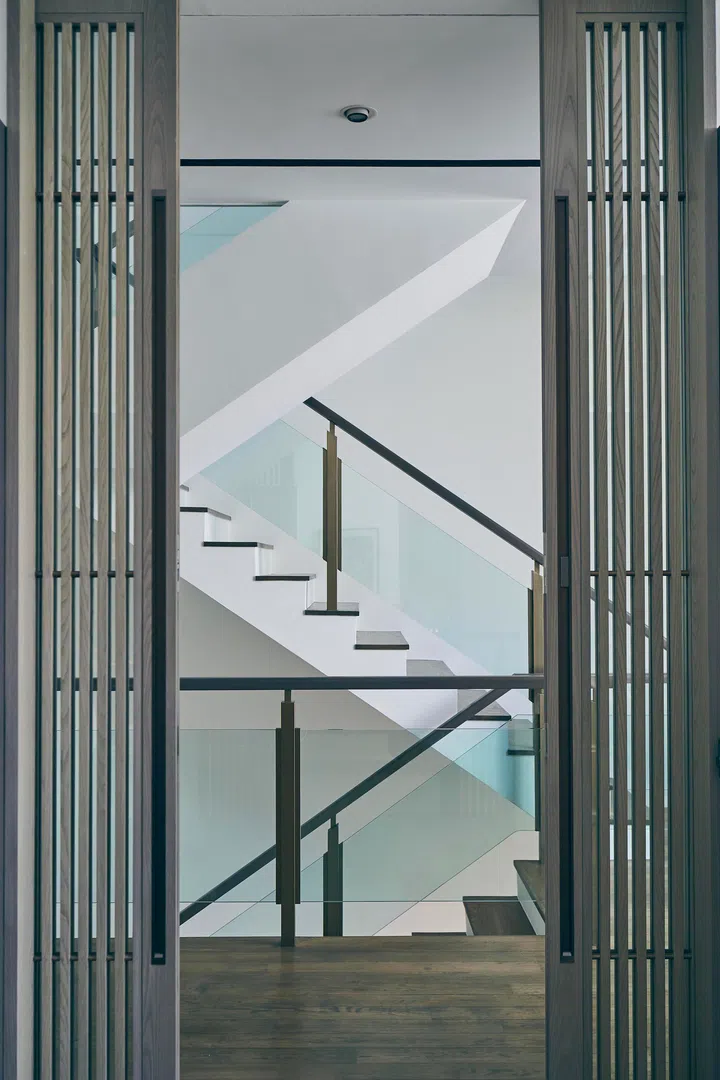 Bespoke double pocket doors introduce a recurring vertical motif while setting the tone of grandeur.