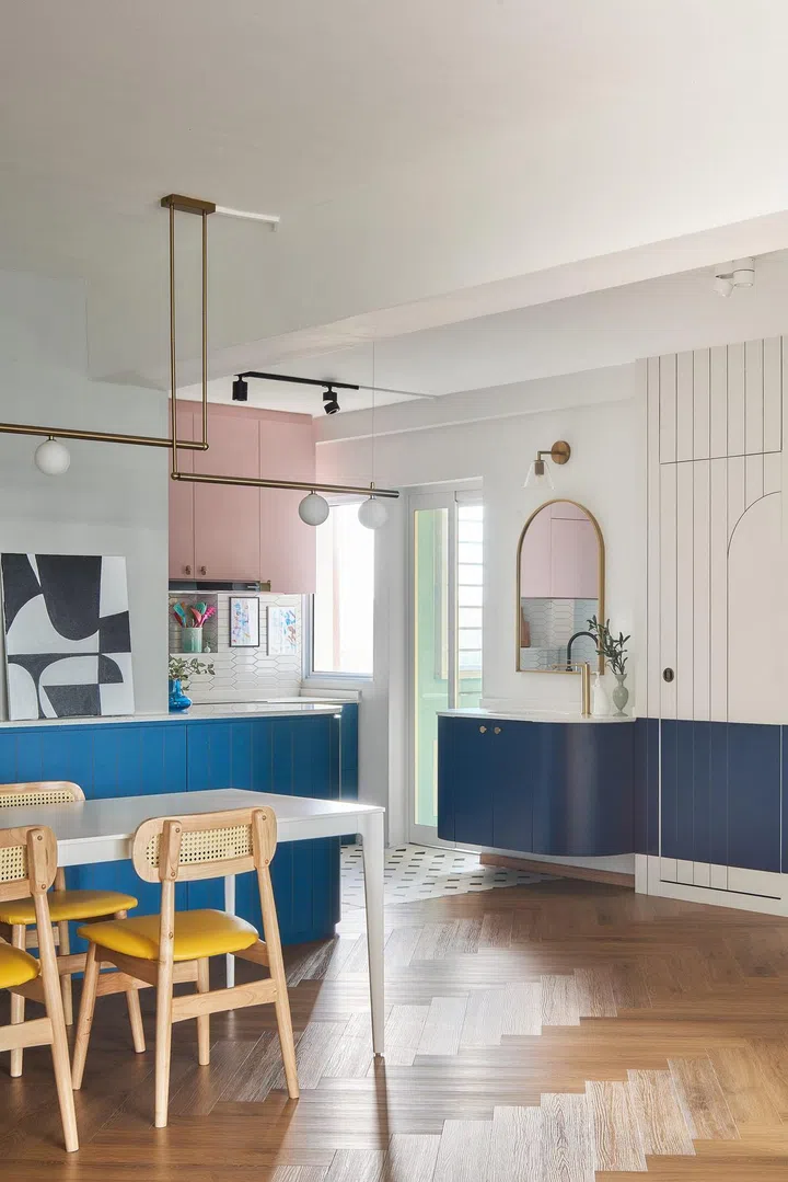 Vinyl herringbone flooring in this 1,592 sq ft HDB executive apartment in Queenstown juxtaposes against the vertical lines on the wall. The door to the bathroom blends with it.