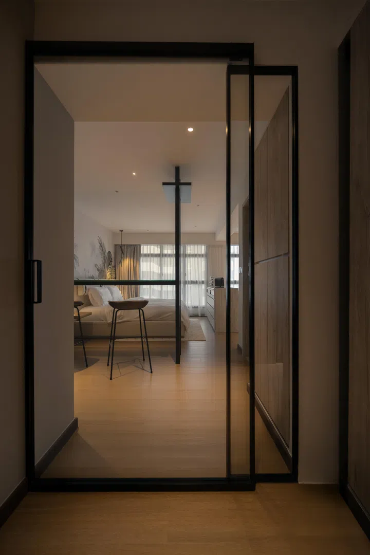 The glass entrance door marks a seamless transition between the kitchen and the open-plan suite beyond.