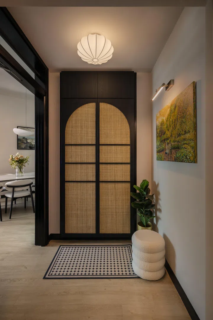 The entrance foyer borrows from a beautiful rattan arched cabinet design in the home bar.