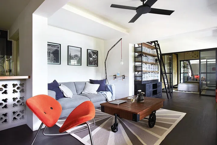 Design Rebirth's Interior designer Victor tore down a store room that sat in the middle of this HDB's living room, giving the homeowners enough space for a sofa and a large coffee table. A series of three framed art photographs hang above the sofa.