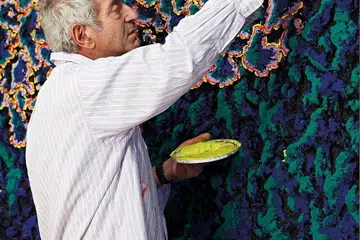 Nabil Nahas, Lebanese artist, at work on one of his huge canvases.