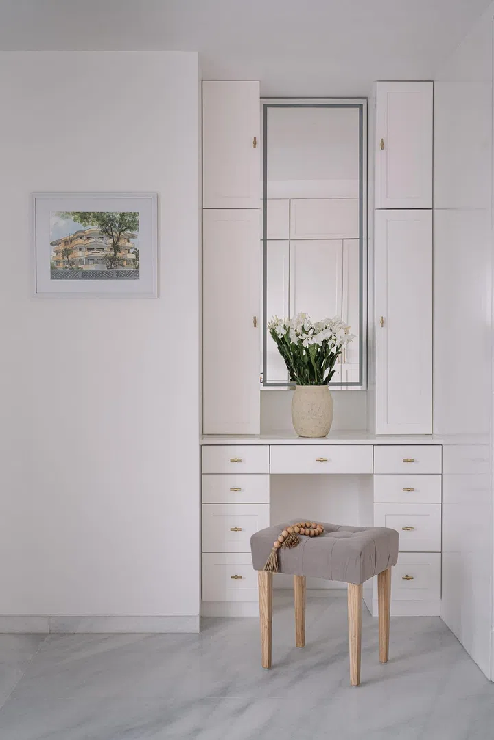 All white and grey vanity desk within the master bedroom of this 2-bedroom apartment in Parsi, Mumbai.