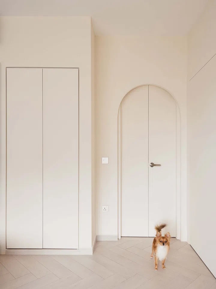 Softly curved arched door closed, adding a whimsical architectural detail that echoes the home’s recurring motif of curves and arches.