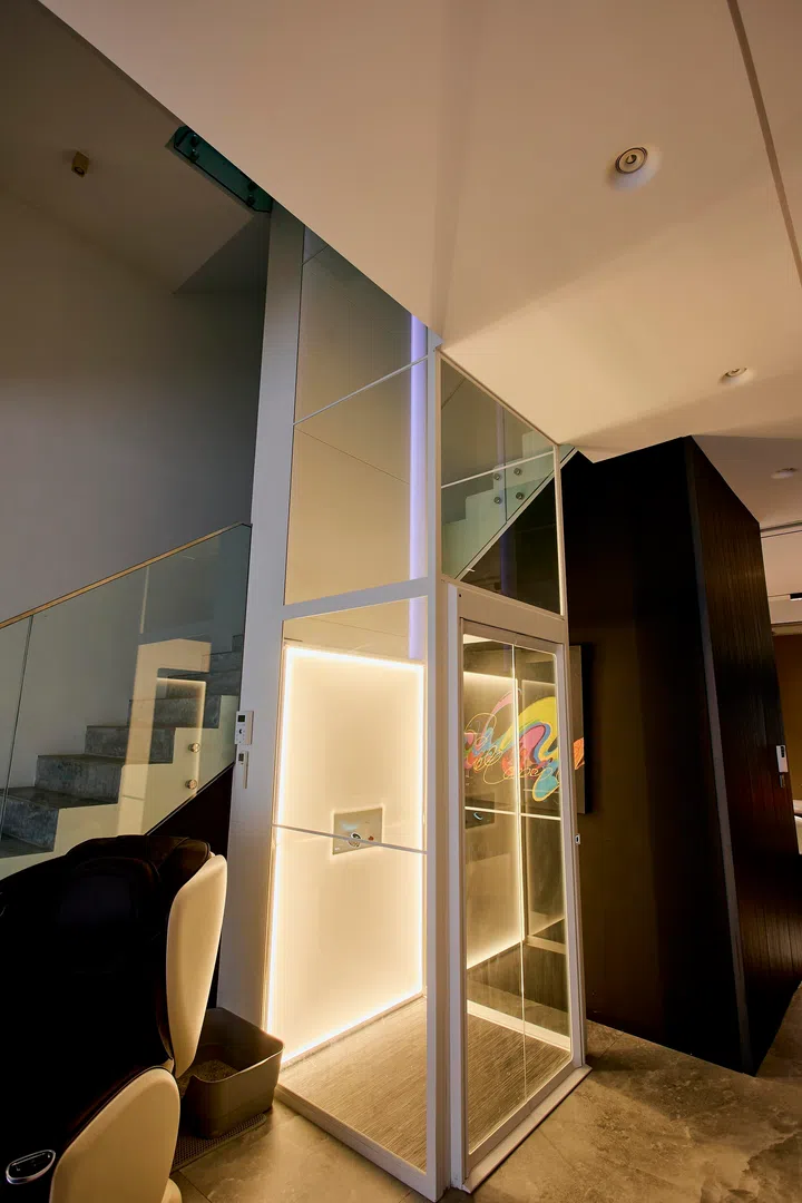 On the ground floor, the three-sided glass lift is designed as a visible feature, with integrated lighting that turns it into a focal point within the space.