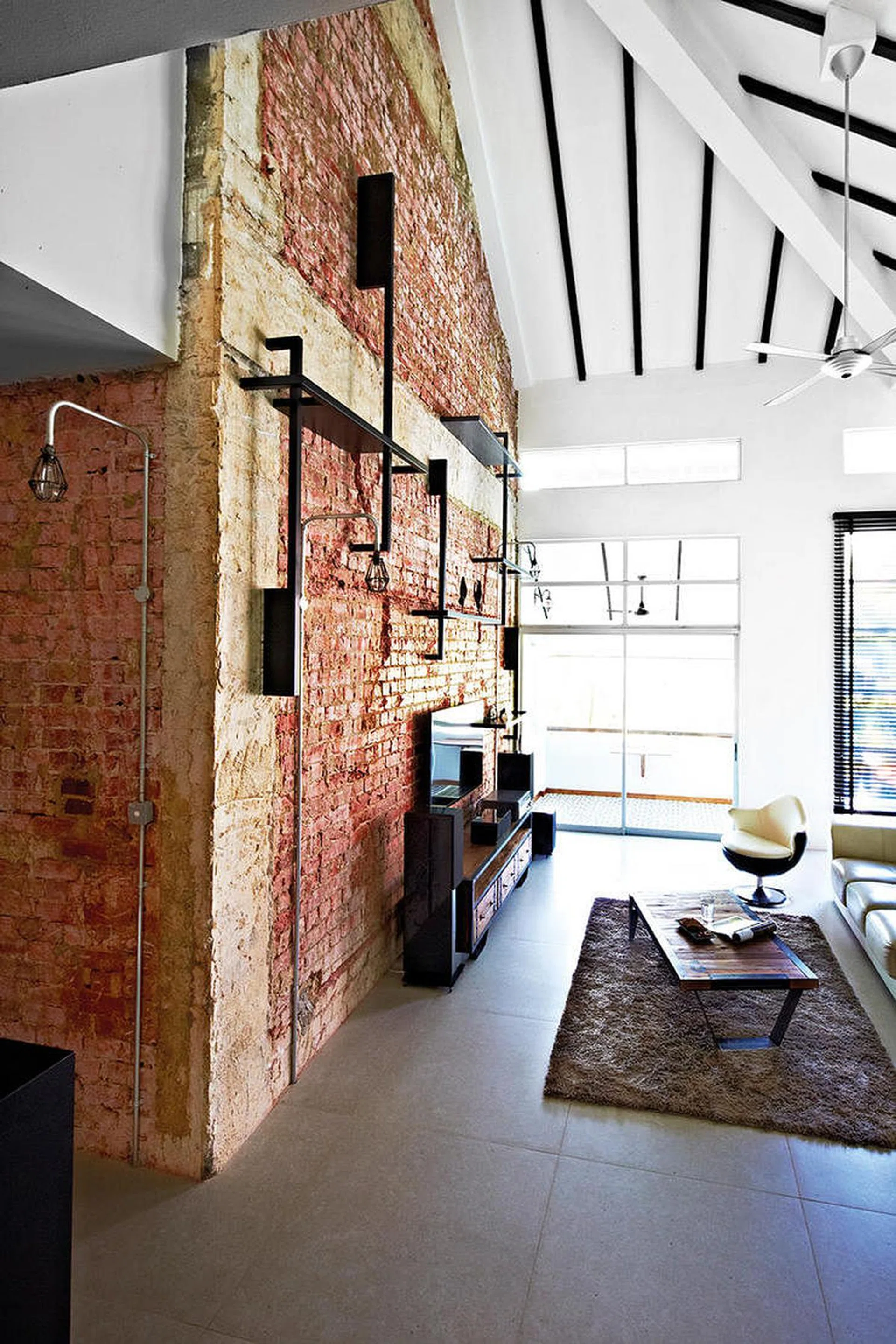 To add texture and character to the space, the homeowners decided to strip the wall to expose the raw bricks. Interior design by Profzile