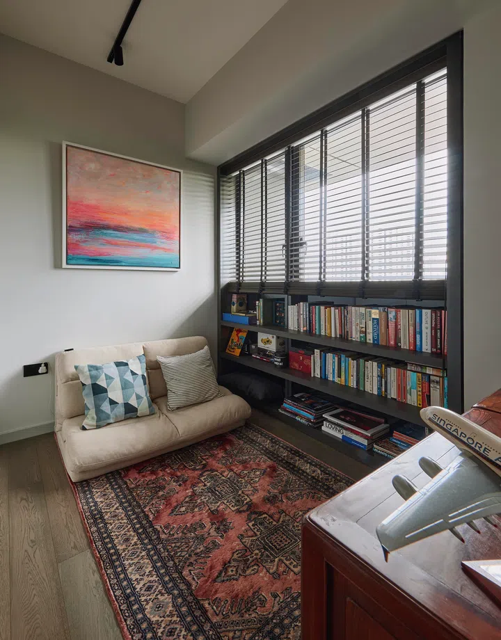A cozy reading nook and functional guest room layered with built-in shelving and personal touches.