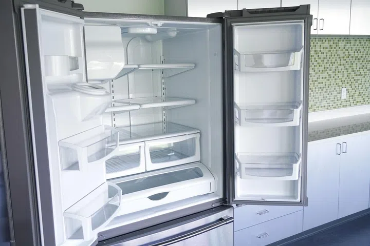 How to Clean Fridge. An empty fridge with doors open to air any odour or unpleasant smells.