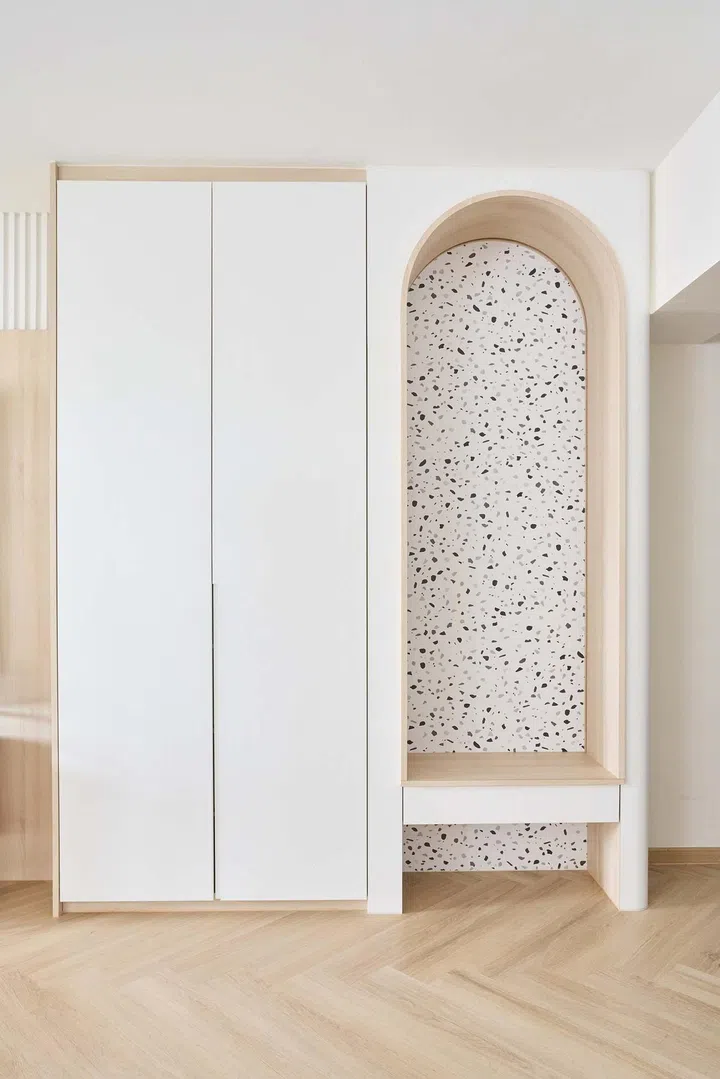 A cosy arch with a bench and shoe cabinet beside the entrance foyer serves as a welcome gesture while addressing a very practical need for somewhere to store and to put on or remove shoes.