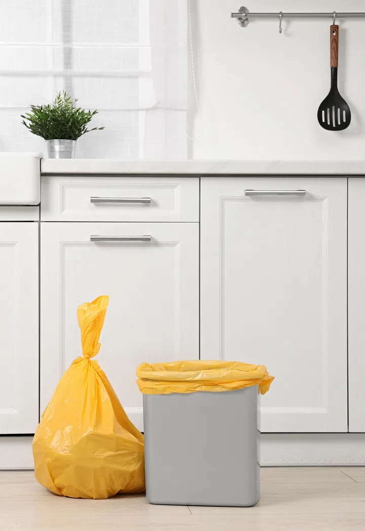 Plastic garbage bag and trash can in kitchen