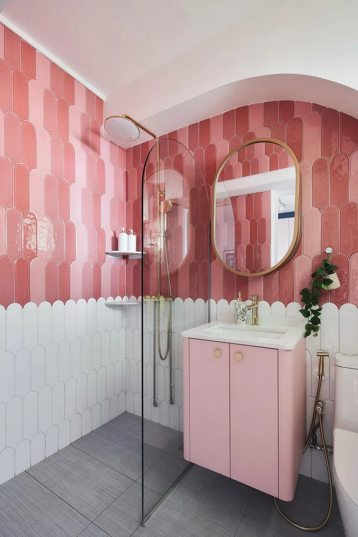 The master bathroom, with its pink ice cream tiles, exudes fun, joy and positivity. Curved edges from the ceiling to the vanity and mirror ensure consistency with the overall design theme.