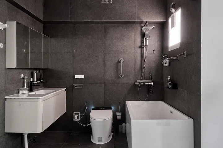 Monochrome en suite master bathroom with a bathtub in a 5-room HDB in Edgedale Plains.