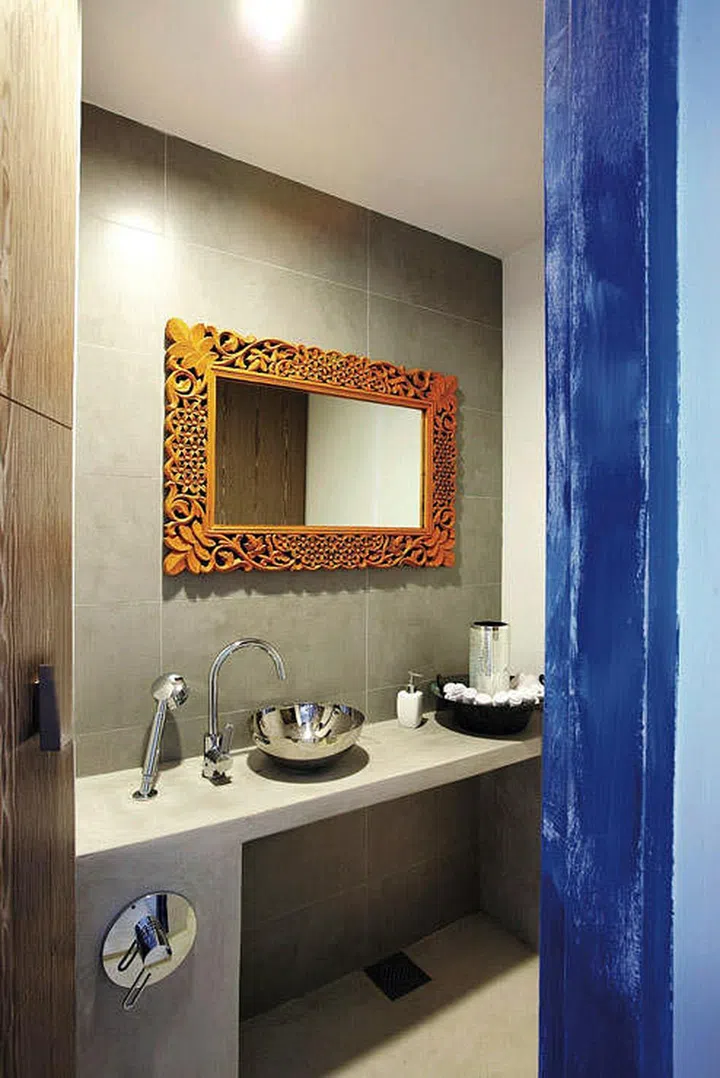 Bold orange and blue colours in the powder room in this 3-bedroom condominium in Pasir Panjang.