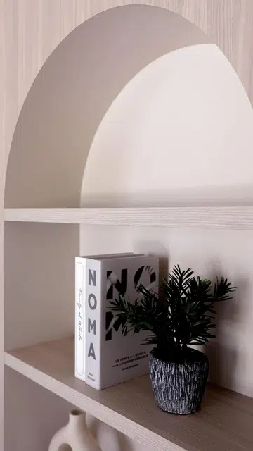Curved niche open display shelves in the living room of a 3-Gen HDB BTO flat in Tengah Garden.