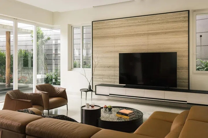 Television feature wall and tan leather sofas in the living room of this 6,534 sq ft semi-detached at Jalan Belibas, Upper Thomson designed by Metre Architects.