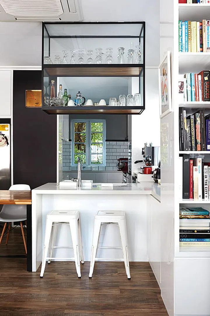 To combat the limited space, a sink was incorporated into the breakfast counter, and cups and stemware are stored in overhead shelves to avoid tabletop clutter.
