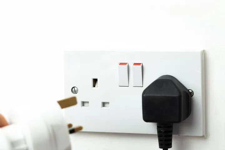 close up of english socket in the wall, electricity bills