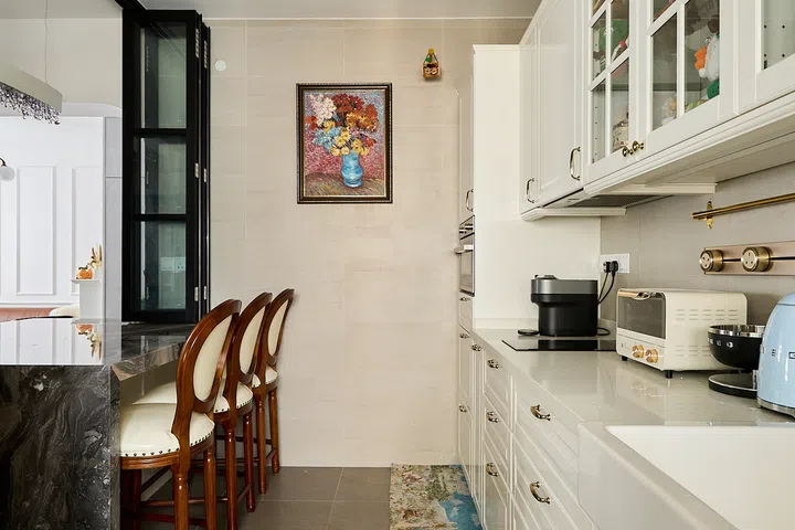 White Shaker cabinetry extends the home’s European influence inside the kitchen.