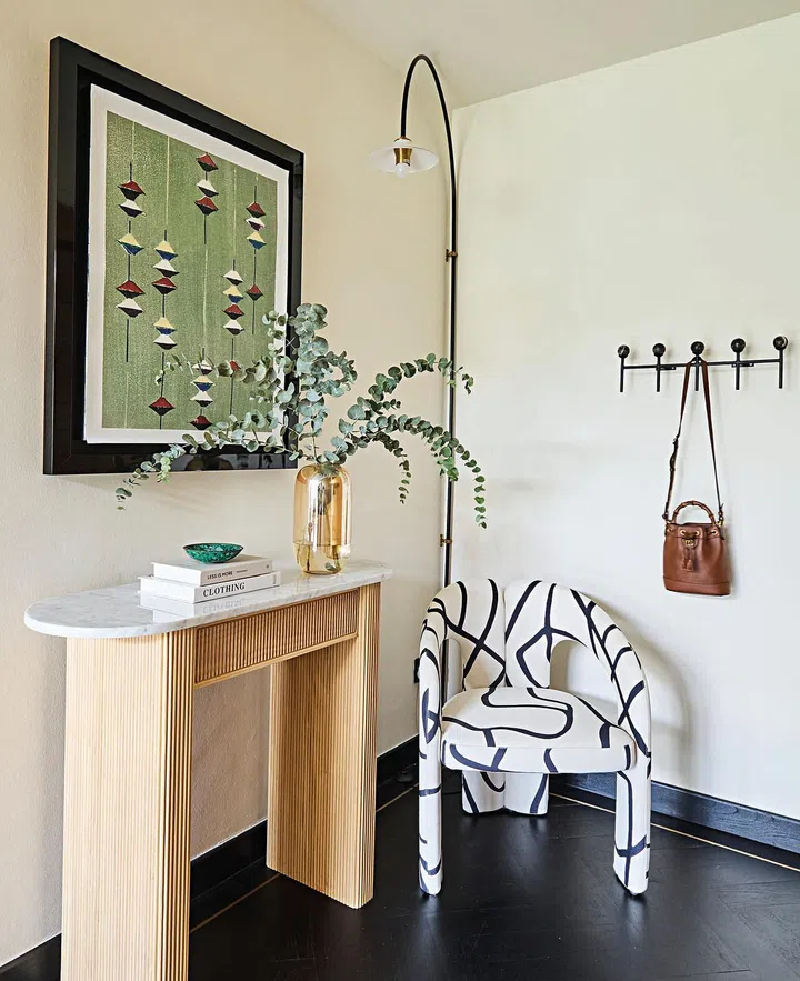 The foyer
is kept
understated
and functional
with a slim
console, an
armchair, and
a spot for
holding daily
must-haves.