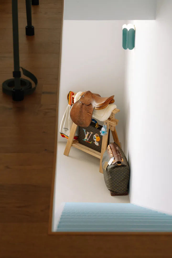 From the loft, the staircase descends into the double-volume living space below, reinforcing the visual connection between both levels.