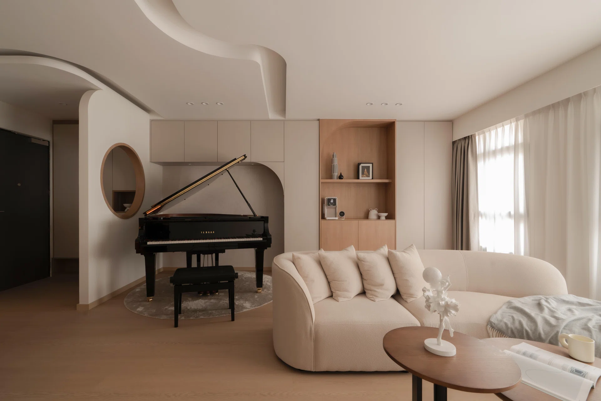 Natural light washes over the sculpted ceiling and piano alcove, where gentle curves frame a grand piano at the heart of the home.