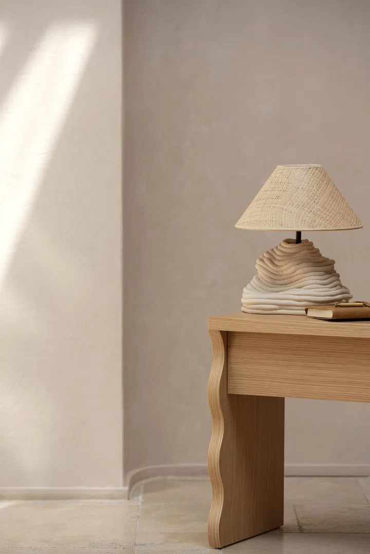 Curvy, sculptural brown table lamp set on a brown wood study table with scallop curvy legs. Image by Natalee Cocks