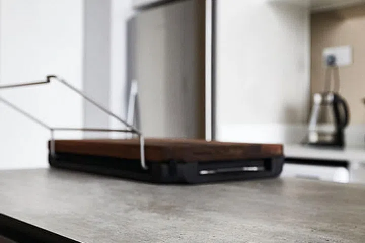 The kitchen island features a textured engineered walnut veneer and a Kompacplus countertop in Denver Travertine in this micro 2-bedroom condo in Dairy Farm.