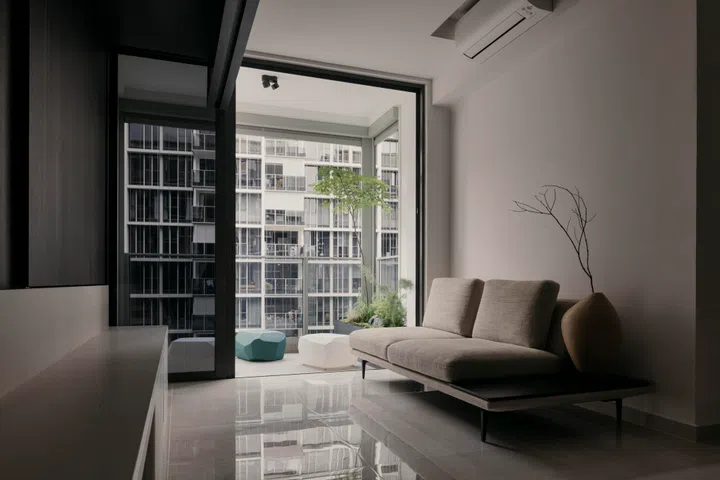 Rock-like Serralunga Meteor stools in the living area mirror the green stone forms seen in Tian Lun Zhi Le at the entry, extending the artwork’s language into the living space of a 3-bedroom (1,098 sq ft) condo in Penrose.