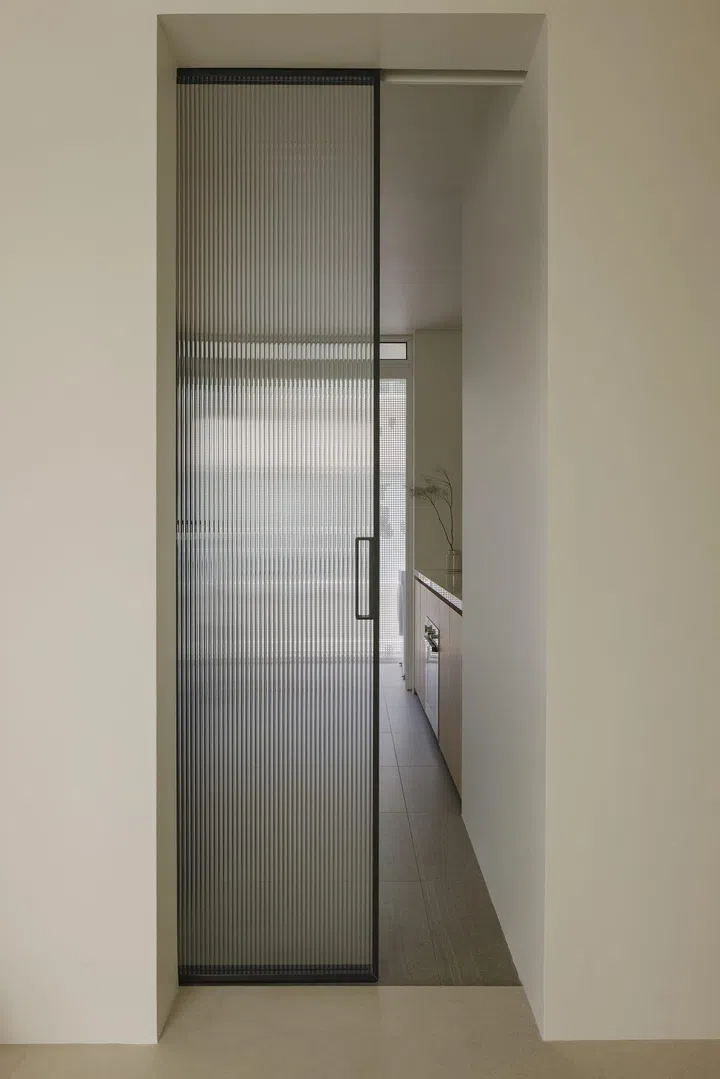 Glass sliding door creates an enclosed kitchen space in this private condominium apartment in Serangoon Gardens.