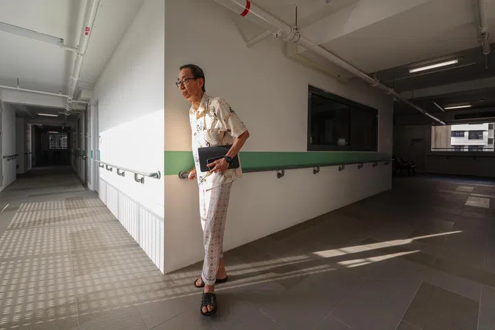 ST20250107_202533200184/ilsenior/Brian Teo/Isabelle Liew/Mr Ong Lye Hock, 79, retired clerk at a chemical company, using the grab rail along the corridor of his 11th floor apartment in Harmony Village @ Bukit Batok on Jan 7, 2025. Previously staying in a maisonette at Jurong East for more than 20 years, he moved into Harmony Village more than a month ago after his divorce. ST PHOTO: BRIAN TEO 