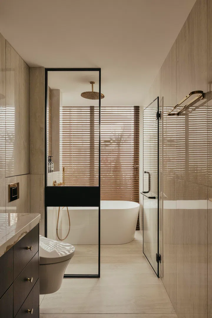 A freestanding bathtub overlooks greenery.  