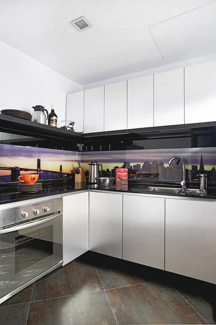 This glass backsplash doubles as a picture frame for this home. Interior design by DistinctIdentity