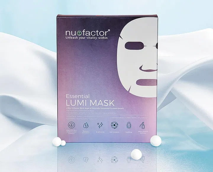 Pink iced refreshment drink in glass with paper drink straw on blue background. Copy space. Summer pastel pink cocktail.