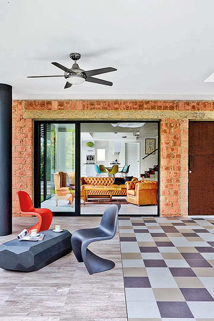 Exposed red brick walls frame the living area, commanding your attention even before you enter the home.