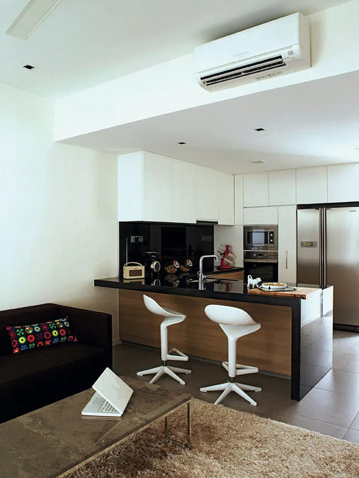 Design icons like Kartell's Spoon bar stools complement the art gallery-feel of this couple's home.