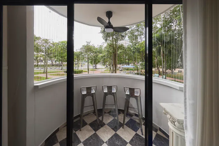 Framed by the living room, the curved balcony remains a daily touchpoint used for morning coffee, quiet observation, and time watching their children play below.