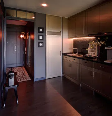 The kitchen, adjacent to the foyer, is equipped with concealed appliances and bold metallic accents.
