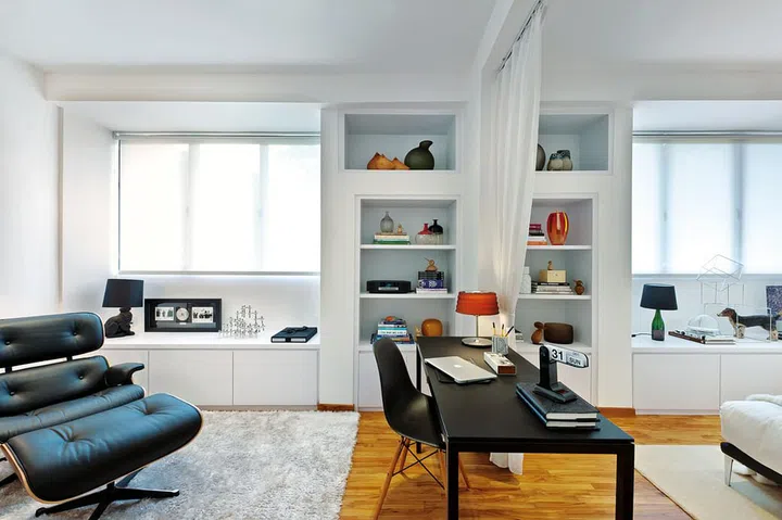 A small desk and sheer curtain segregate, but not separate, the lounging and sleeping areas in the bedroom.