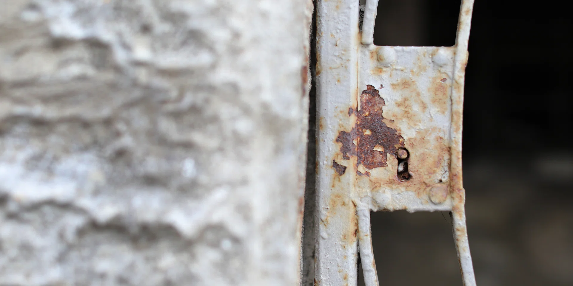 A close-up view reveals the beauty of rust and decay on a weathered metal latch