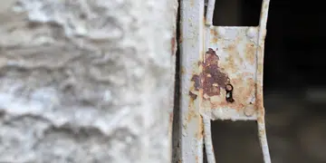 A close-up view reveals the beauty of rust and decay on a weathered metal latch
