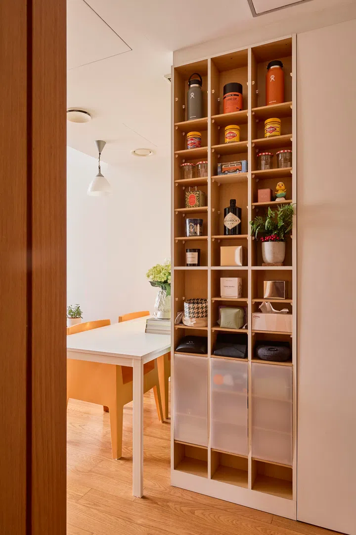 A tall, narrow shelving unit keeps everyday items neatly organised, supporting the home’s clean and uncluttered look.