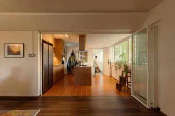 Bathed in daylight and framed by greenery, the reconfigured flat feels open and welcoming from the moment you step inside.