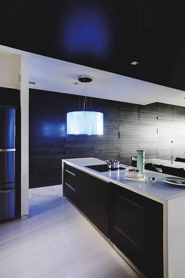 The kitchen island countertop came with the home, but was moved to make more space for the dining area in this dark modern 4-bedroom condominium in Sentosa Cove.