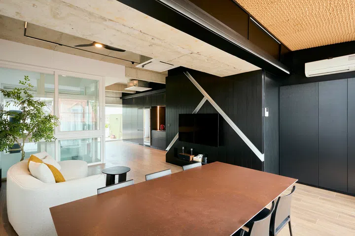 The fourth-floor space combines lounging and dining within an open layout, with the glass lift maintaining visual continuity across levels.