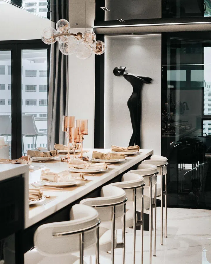 A long marble dining table with curved dining chairs